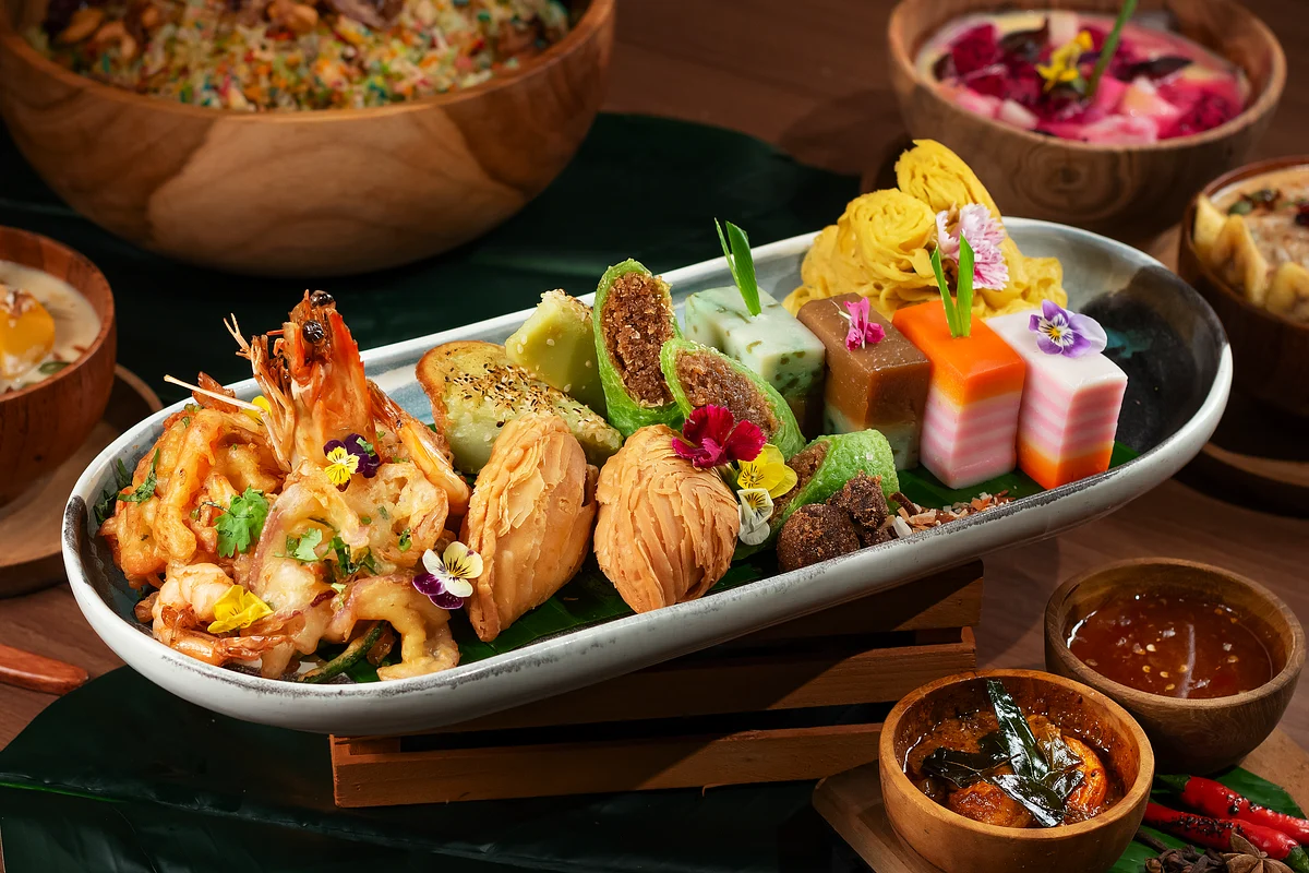 Assorted colorful appetizers with prawns, sushi-like cubes, dumplings, and edible flowers