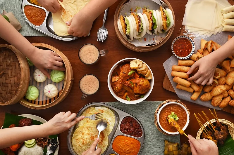 Overhead spread of assorted dishes with people serving food at a shared table
